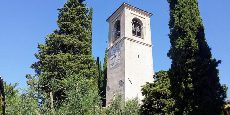Historischer Glockenturm in San Felice del Benaco, eingerahmt von Zypressen und mediterraner Vegetation