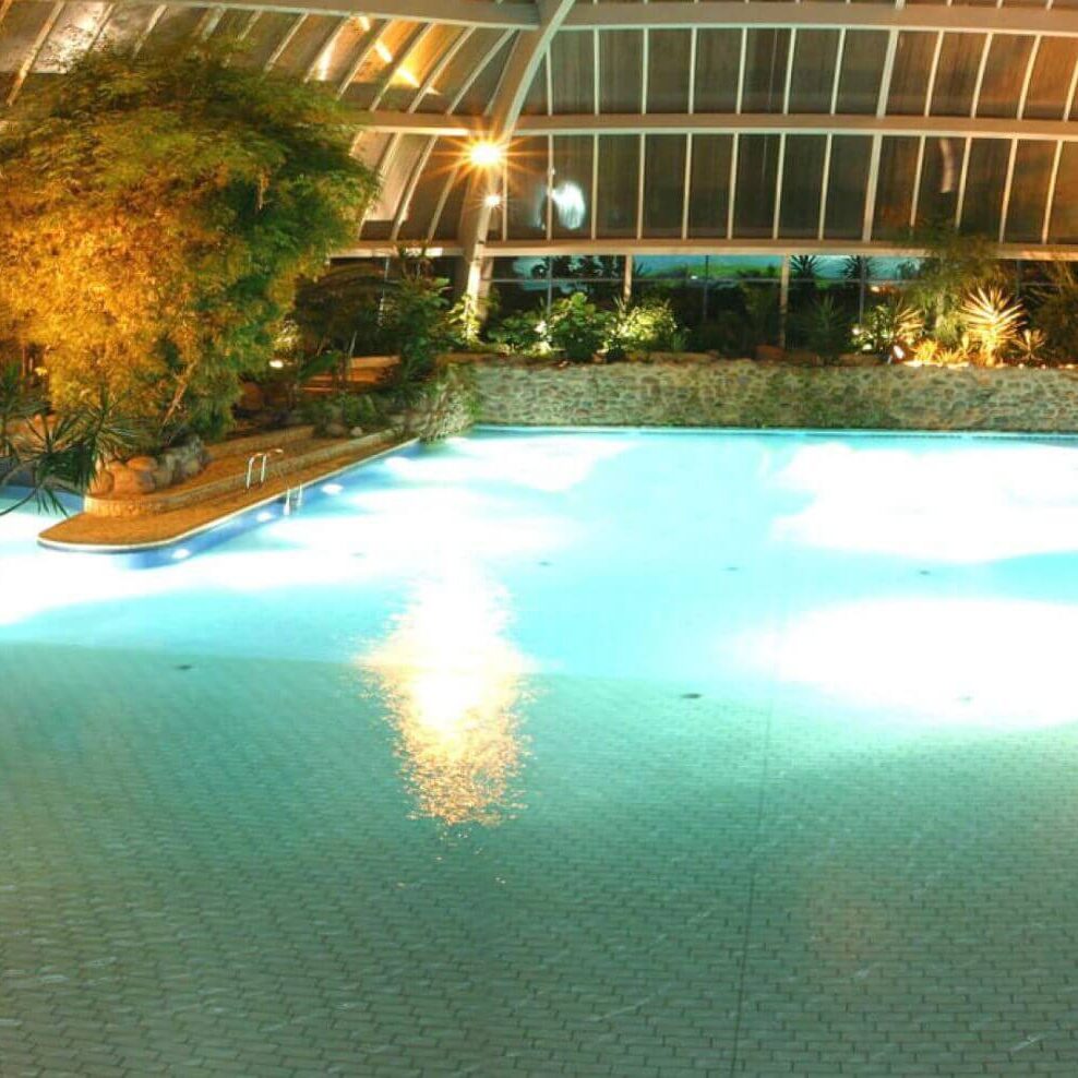 Tropische Badelandschaft mit Innenpool und üppiger Begrünung