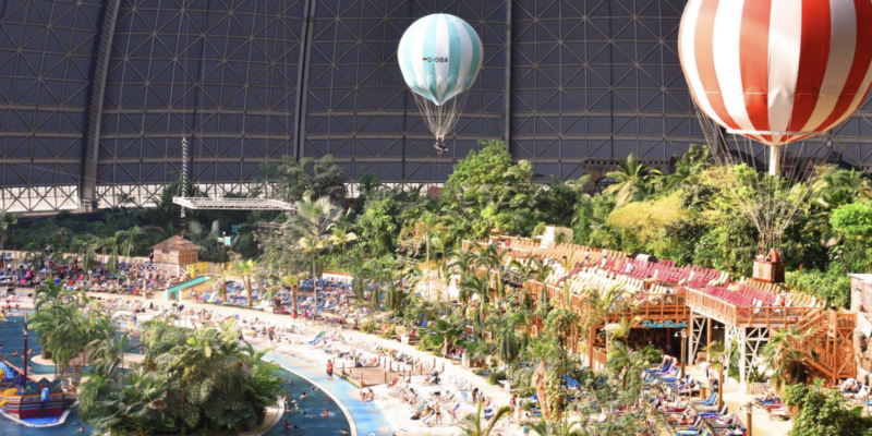 Die tropische Südsee mit Indoor-Heißluftballons Panorama-Blick über die riesige Südsee-Halle im Tropical Islands nahe Berlin mit Sandstrand, Liegestühlen, echtem Regenwald und zwei schwebenden Indoor-Heißluftballons unter dem Kuppeldach.