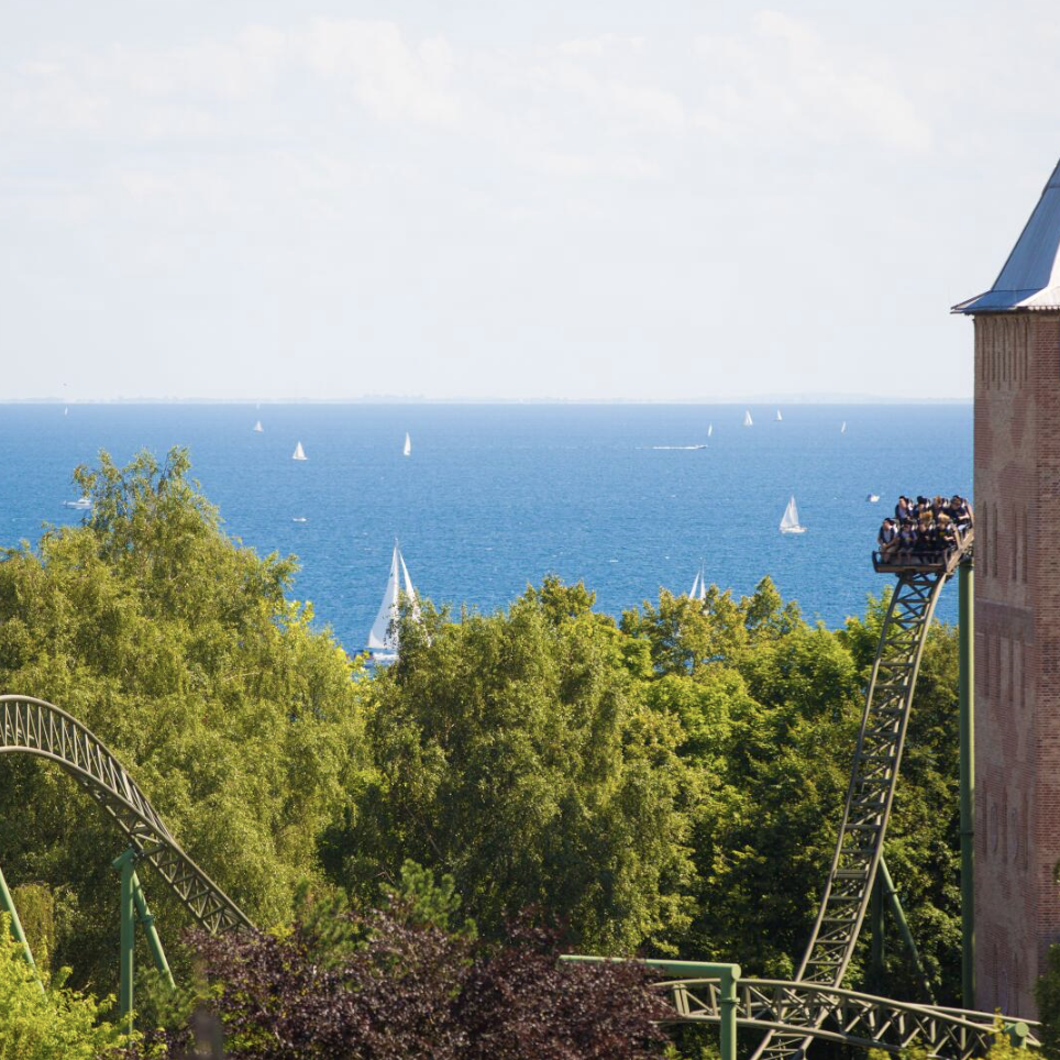 HANSA-PARK mit Achterbahnschienen, Backsteinturm und Blick auf die Ostsee